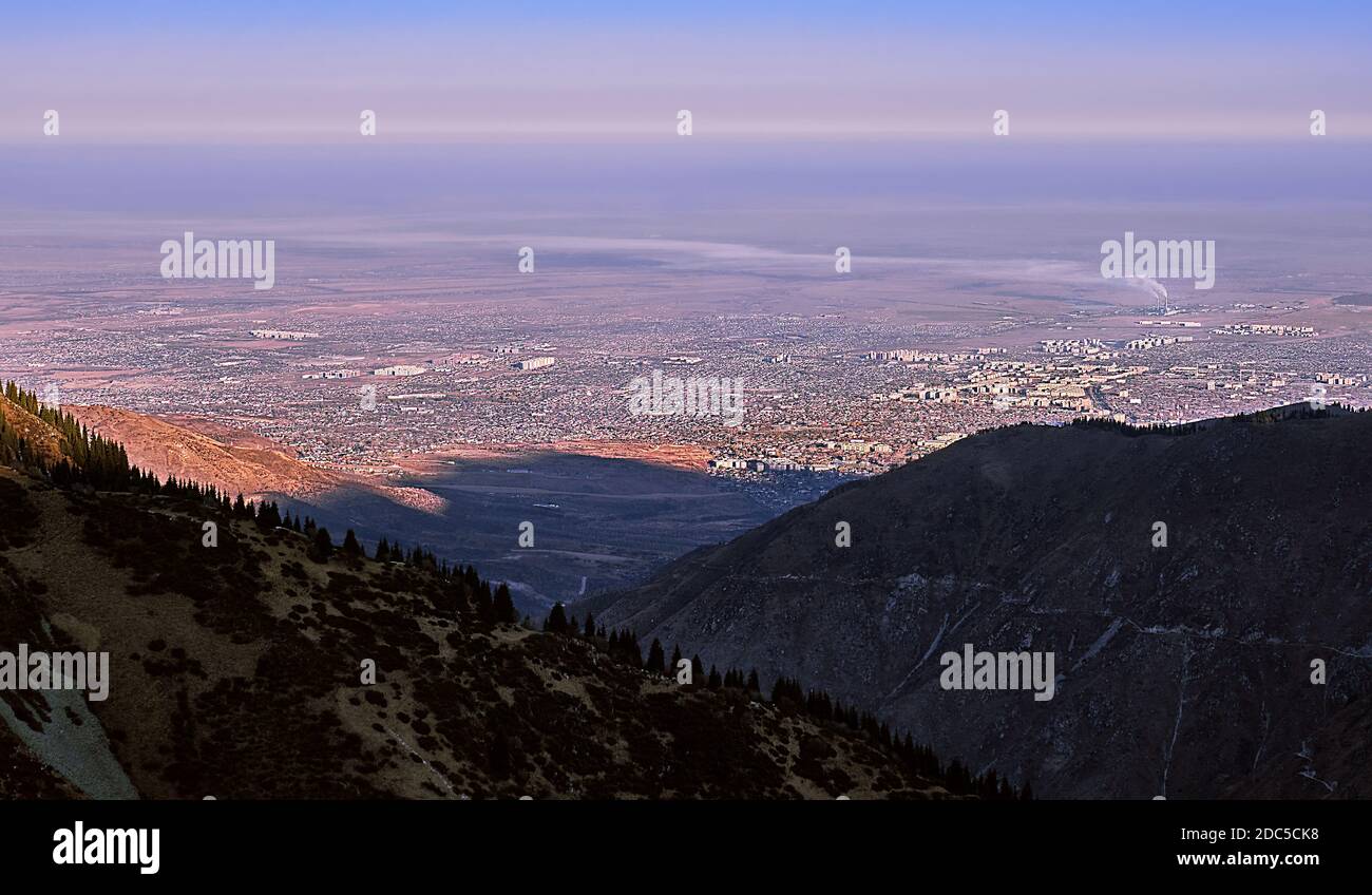 Stadt am Fuße der Berge bei Sonnenaufgang; Almaty Stadt, Kasachstan Stockfoto