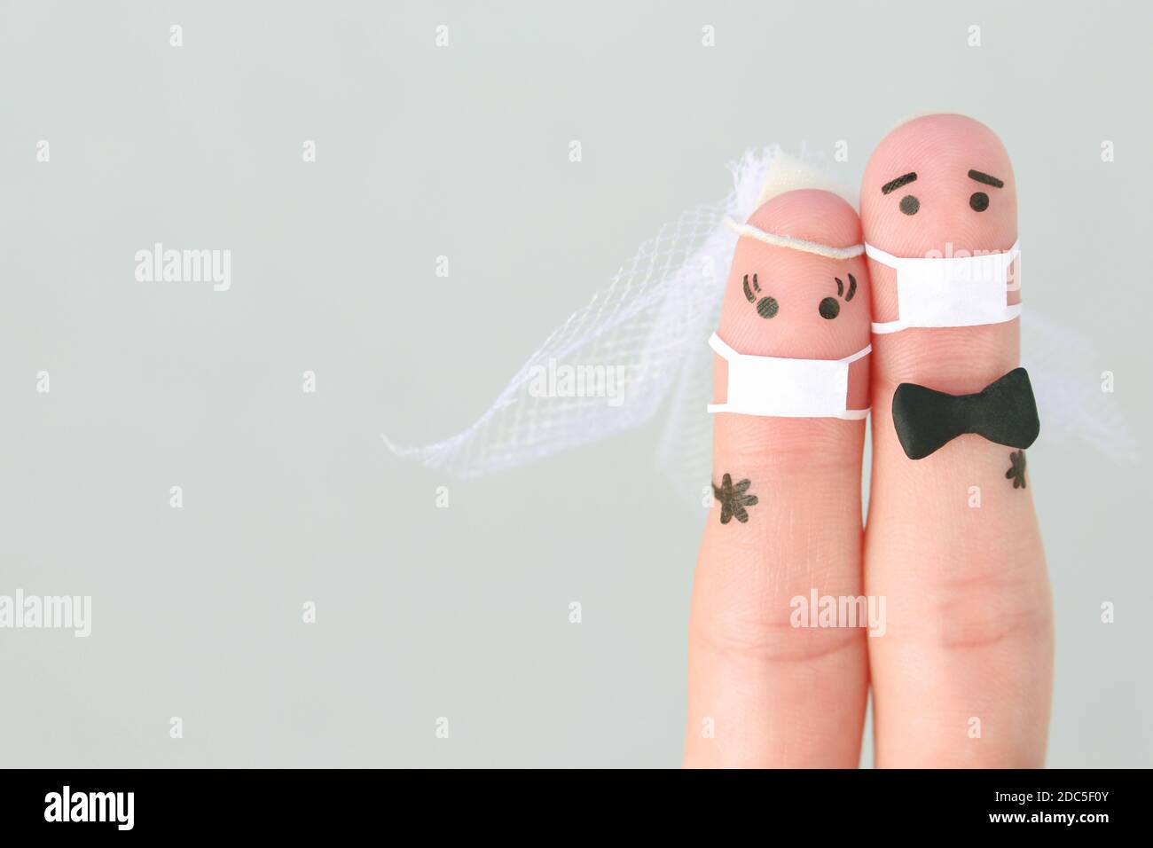 Finger Kunst des glücklichen Paares in medizinischer Maske von COVID-2019. Konzept der Hochzeitszeremonie. Stockfoto