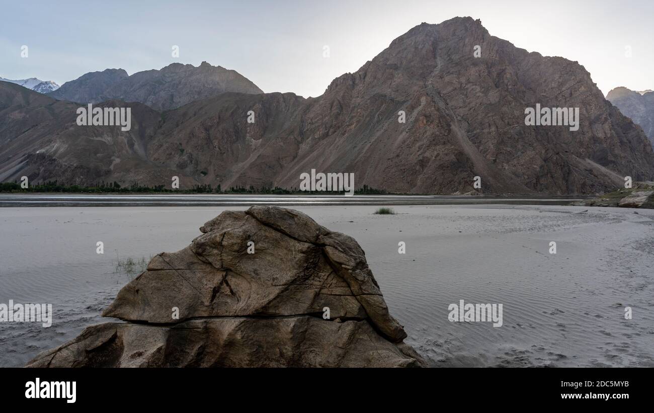 Strand am Pyandzh Fluss und Tal mit hohen Bergen bei Vilojati in Tadschikistan mit Afghanistan an der anderen Seite des Flusses. Stockfoto