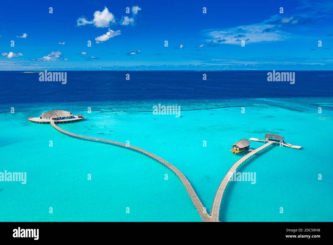 Atemberaubende Luftlandschaft, Malediven-Insel, Luxus-Wasser-Villen-Resort und hölzernen Pier. Schöner Himmel und Wolken und Strand, Sommerurlaub Stockfoto