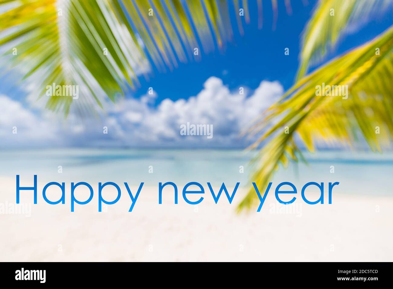 Frohes neues Jahr in den Himmel geschrieben. Künstlerischer Sommerurlaub am Strand mit Silvesterkonzept Stockfoto