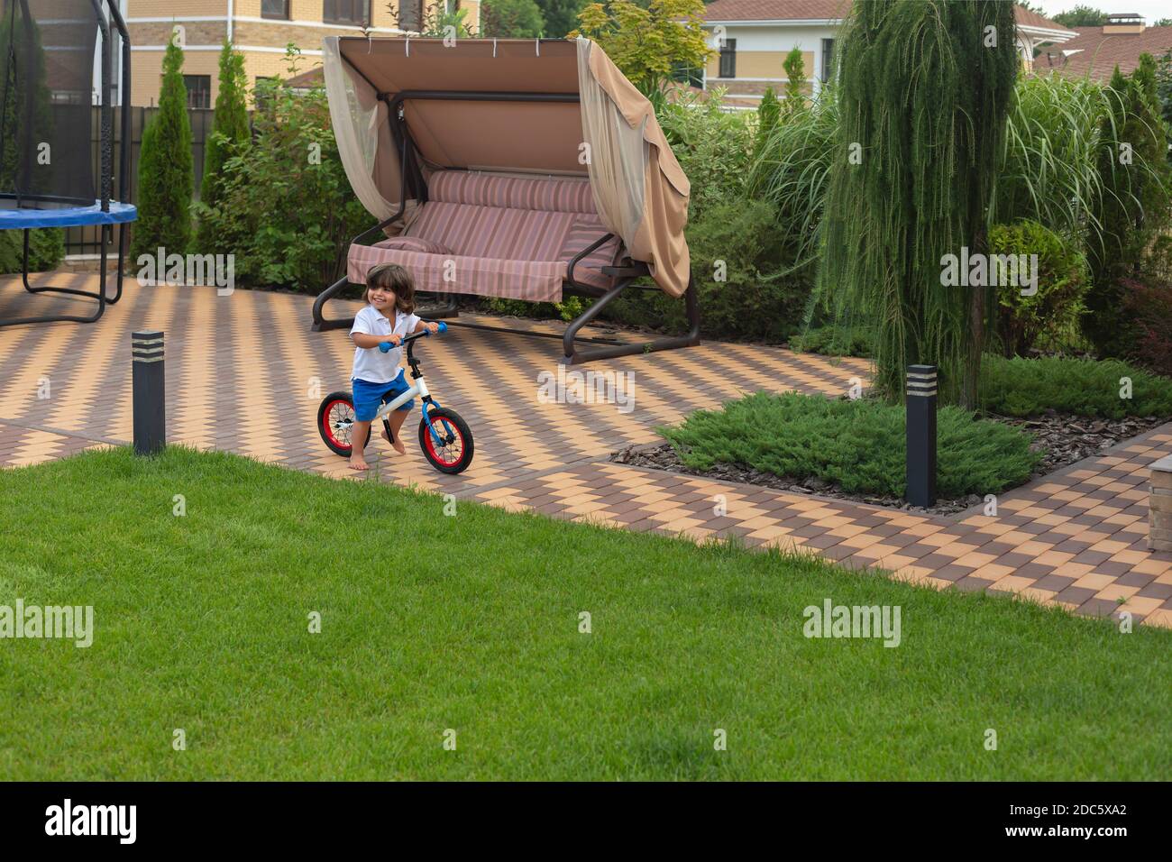 Sorglos Kleinkind Junge Fahrrad im Hinterhof reiten Stockfoto