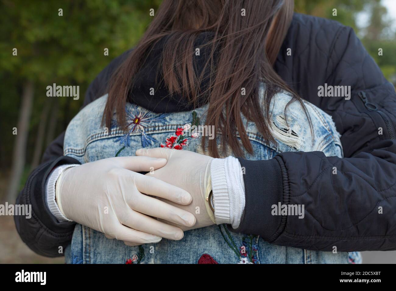 Nahaufnahme liebevollen Mann in Gummihandschuhe umarmt Freundin Stockfoto