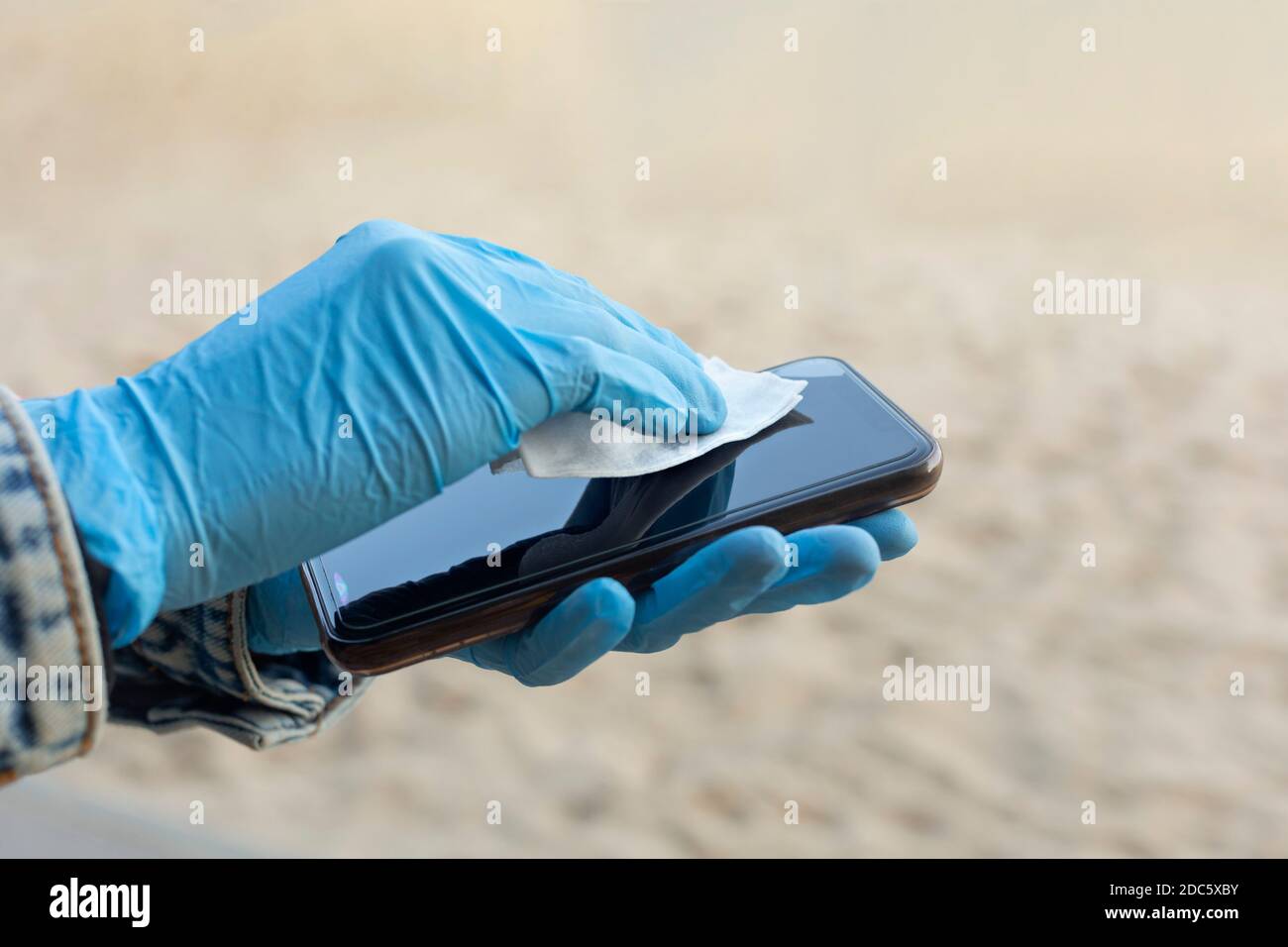 Nahaufnahme Frau in Gummihandschuhen wischen Smartphone-Bildschirm Stockfoto
