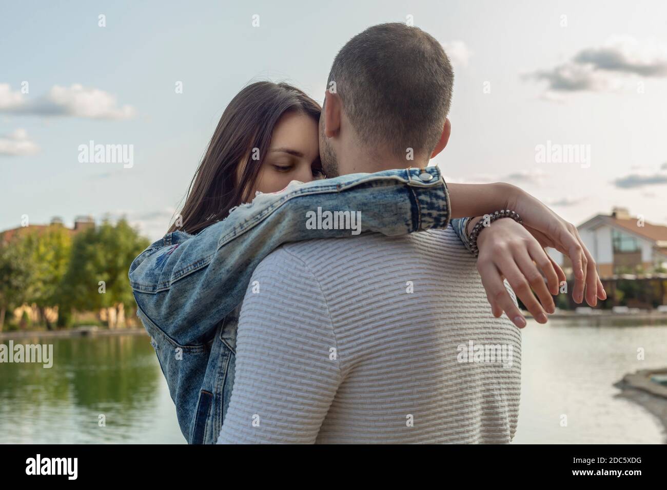 Ruhiges, liebevolles junges Paar, das sich am See umarmt Stockfoto