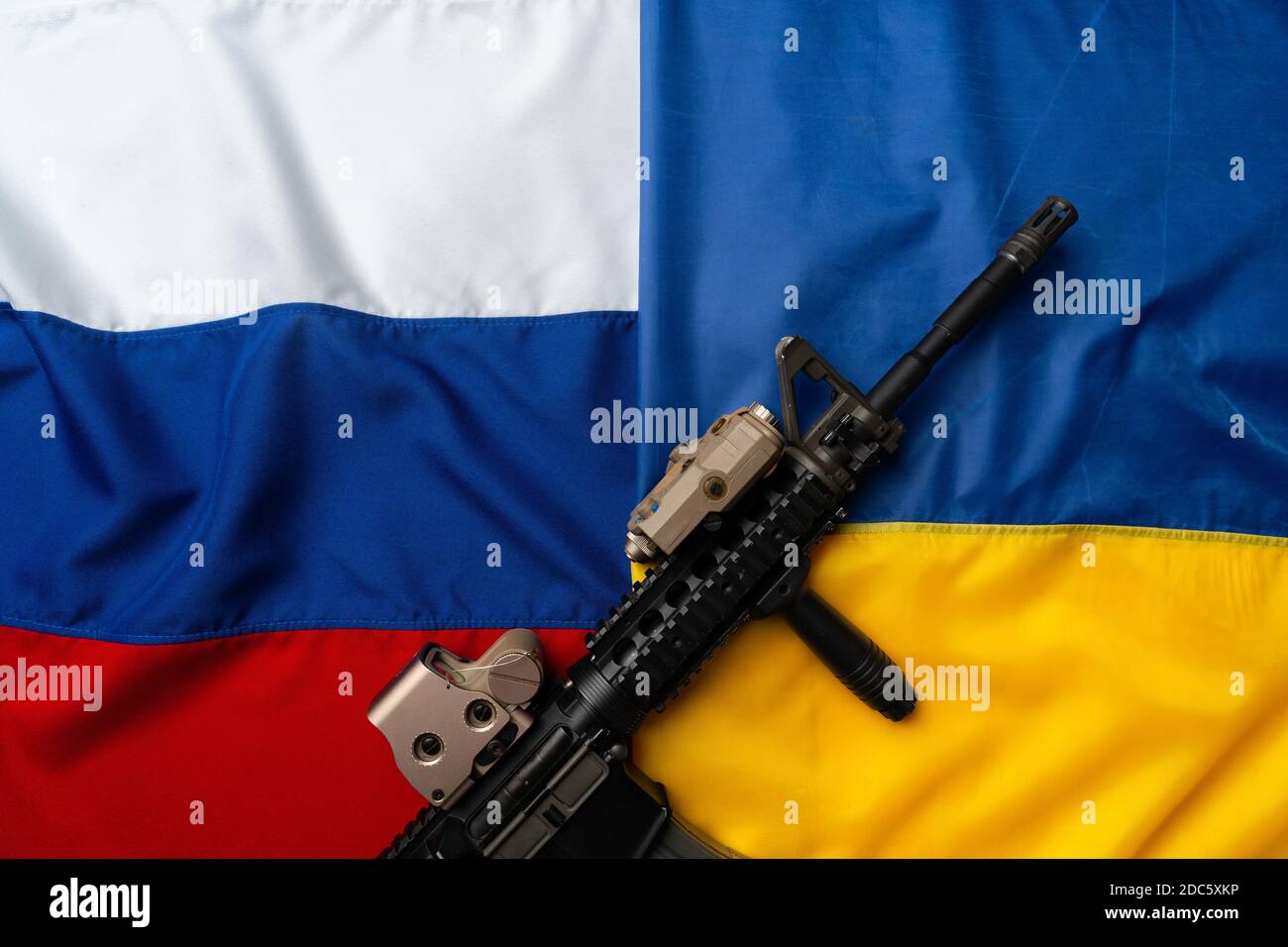 Flaggen von Russland und der Ukraine gefaltet zusammen mit Gewehr Stockfoto