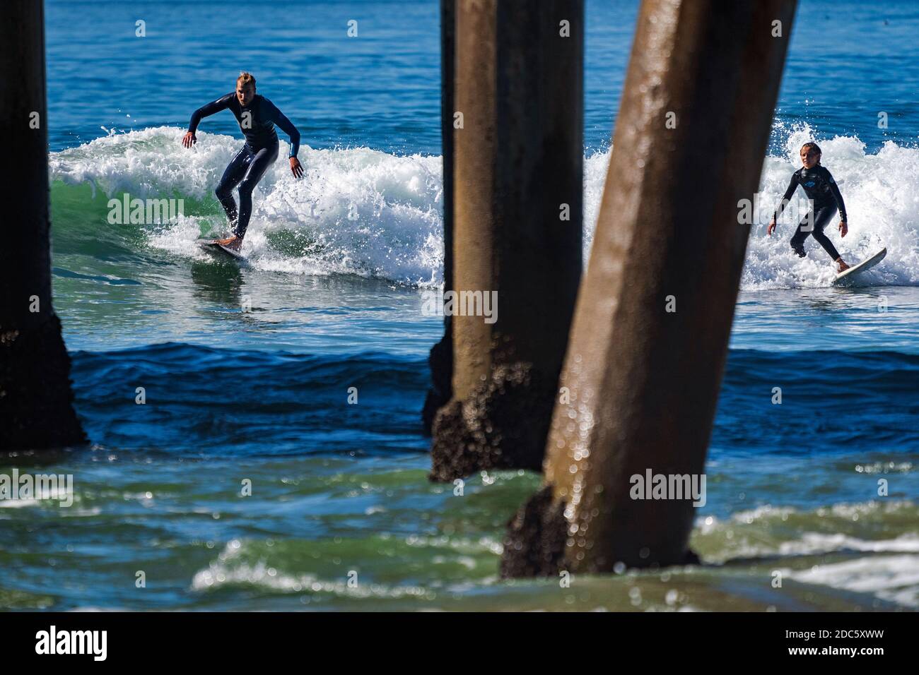 Surfer reiten auf einer Welle, während eine Königsflut Huntington Beach, Kalifornien, erreicht. Die Hochfluten, bekannt als King Tides, trafen die Südkalifornien Küste mit Wellen, die 7 Fuß erreichen. Stockfoto
