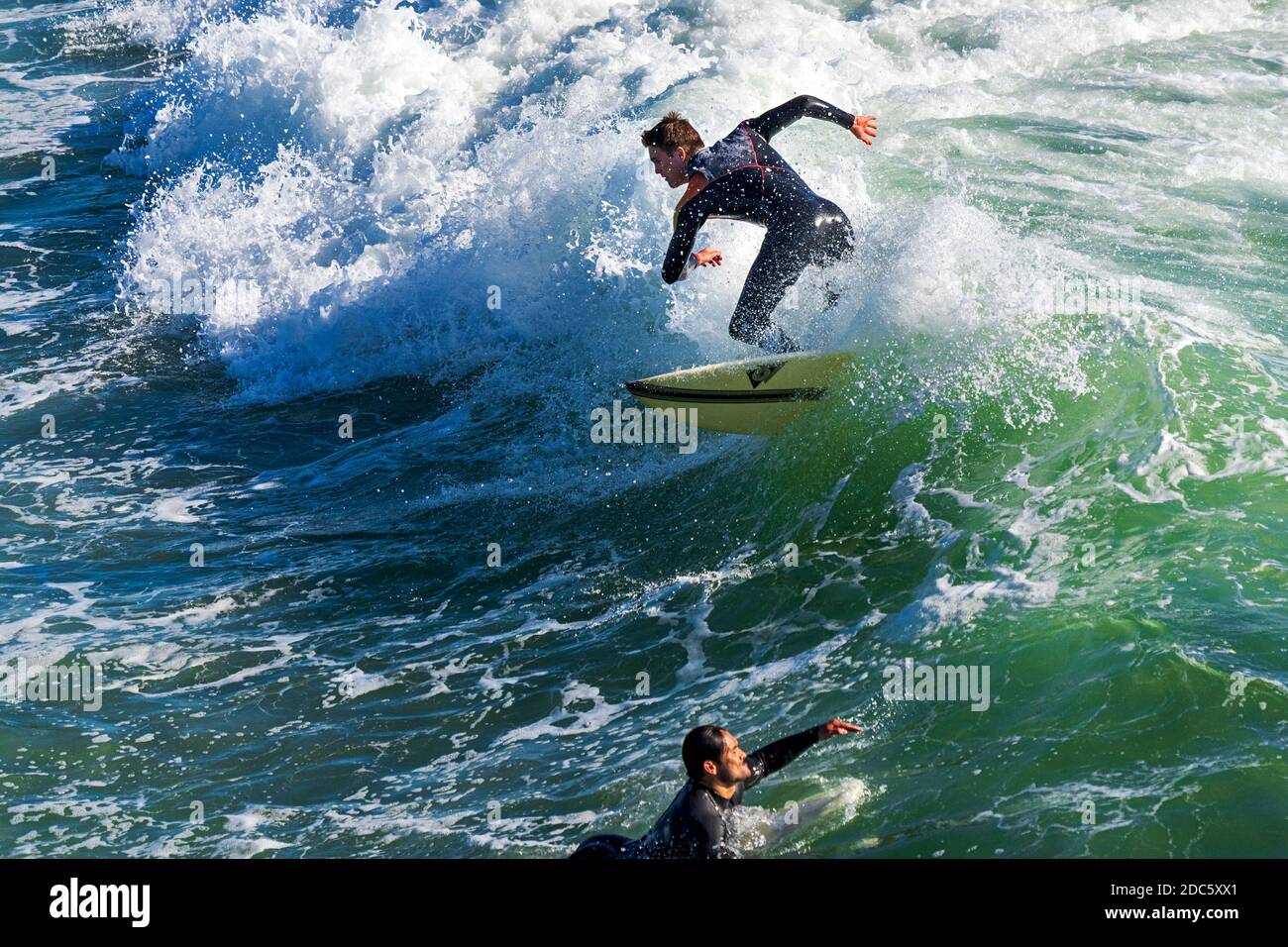 Surfer reiten auf einer Welle, während eine Königsflut Huntington Beach, Kalifornien, erreicht. Die Hochfluten, bekannt als King Tides, trafen die Südkalifornien Küste mit Wellen, die 7 Fuß erreichen. Stockfoto