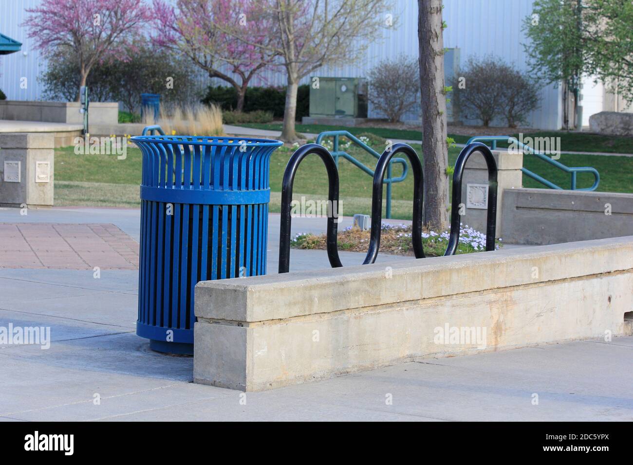 Hutchinson Kansas City Park mit grünem Gras, Bäumen, Mülleimer und Zement Side Walk an einem Frühlingstag. Stockfoto