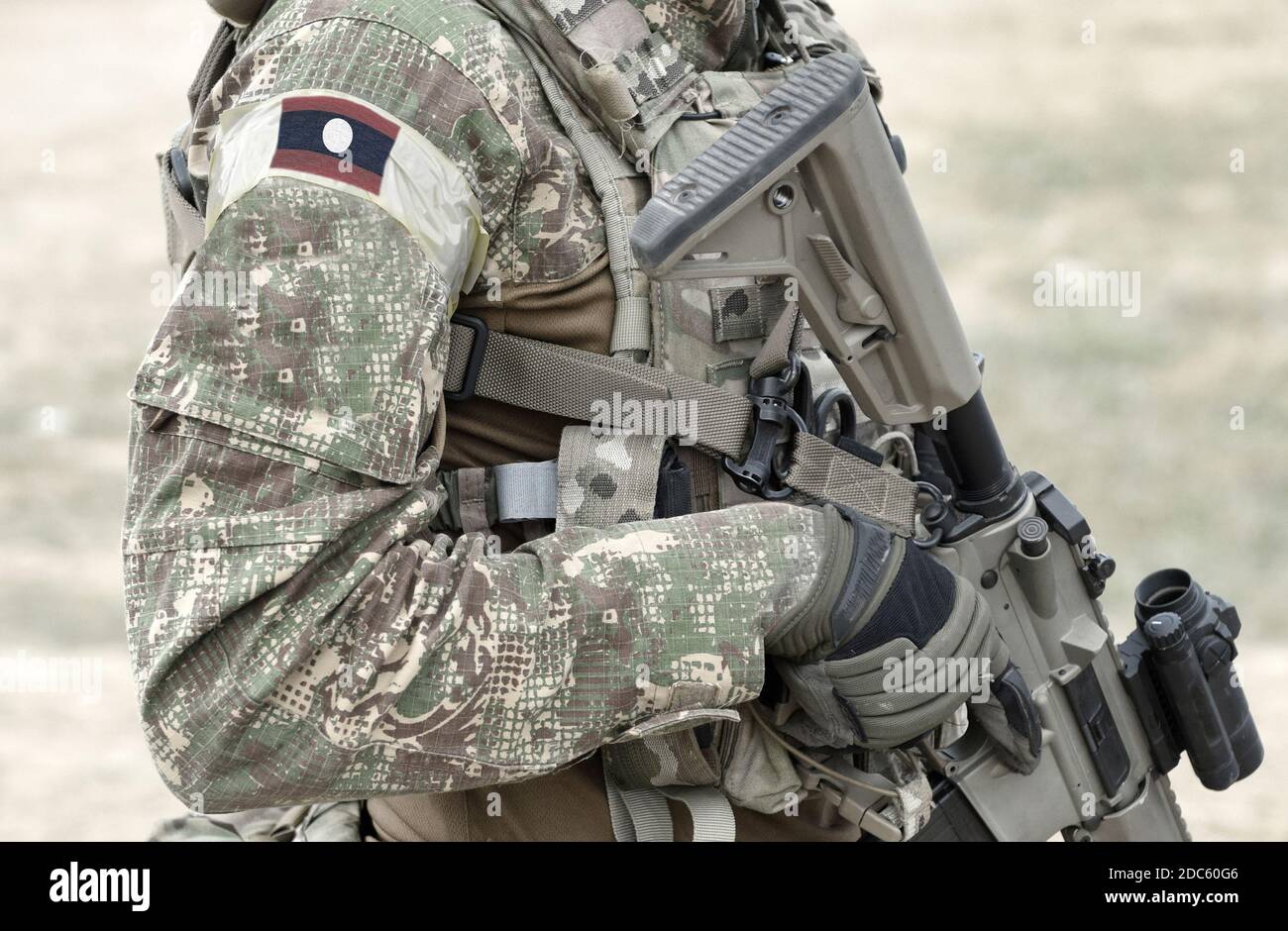Soldat mit Sturmgewehr und Flagge von Laos auf Militäruniform. Collage. Stockfoto