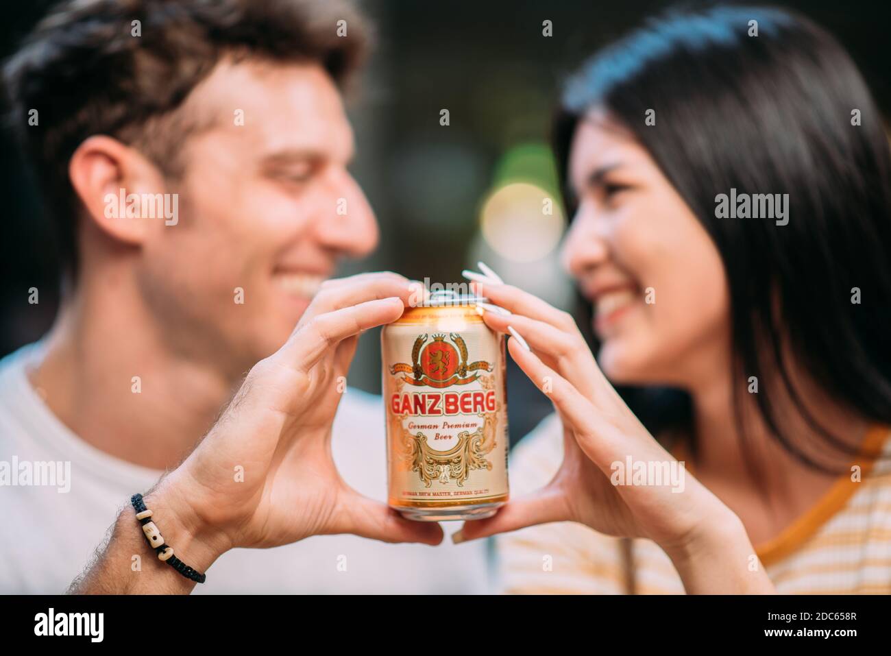 Bier-Party - Junges Paar genießen heißen Sommertag auf einer Dachparty, trinken Ganzberg Bier und Spaß haben Stockfoto