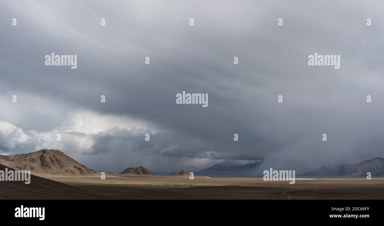 Regen am Karakul See mit Blick auf hohe Berge, die Wüste und ein Tal in Tadschikistan. Stockfoto