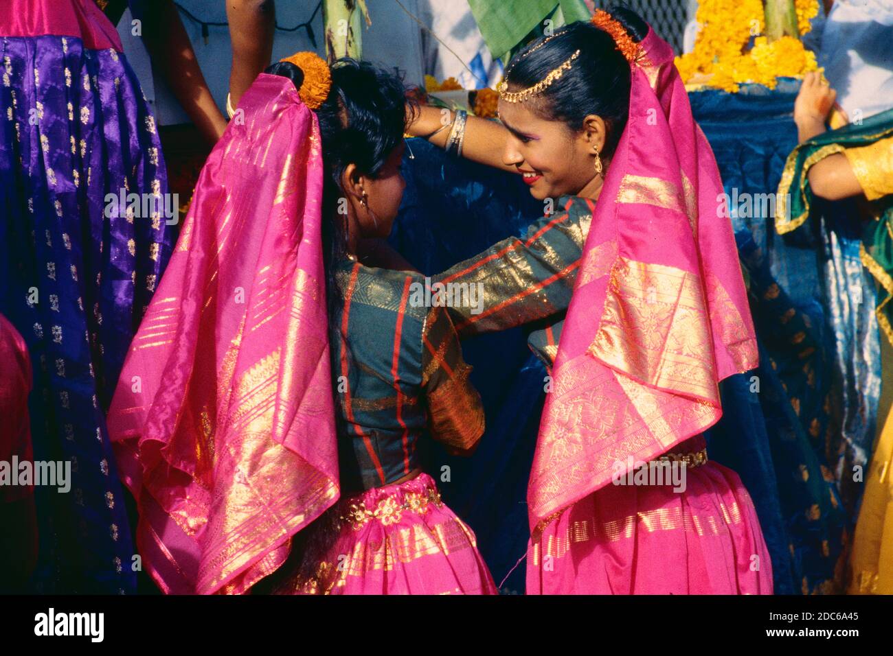 Lächelnde fröhliche indische Frauen oder hinduistische Frauen tragen traditionelle Kleidung und fließende Kopfschmuck Vorbereitung Karneval Schwimmer für Diwali, das indische Festival der Lichter, in Reunion Island Frankreich Stockfoto