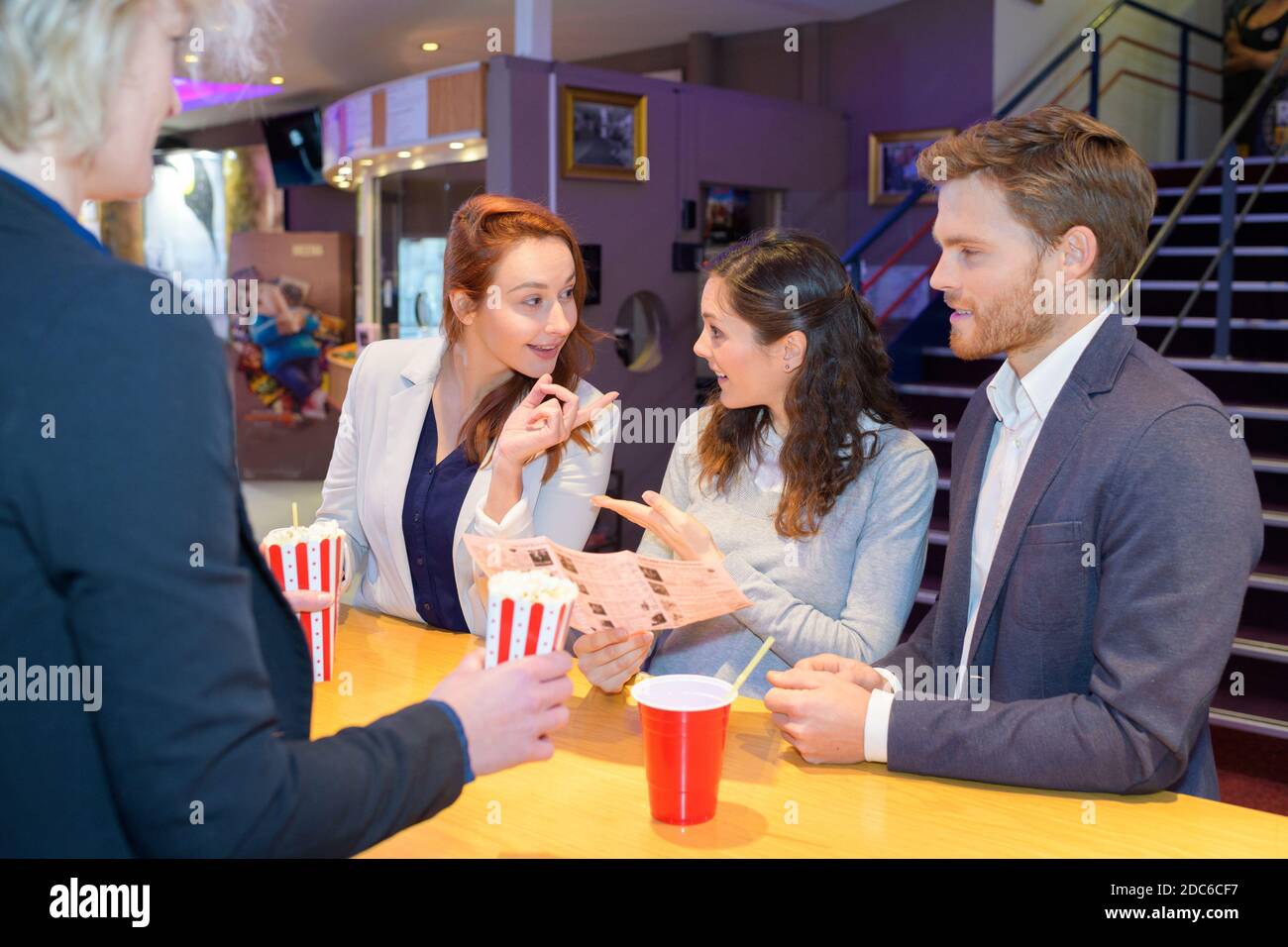 Freunde treffen sich in der Lobby-Lounge des Kinos Stockfoto