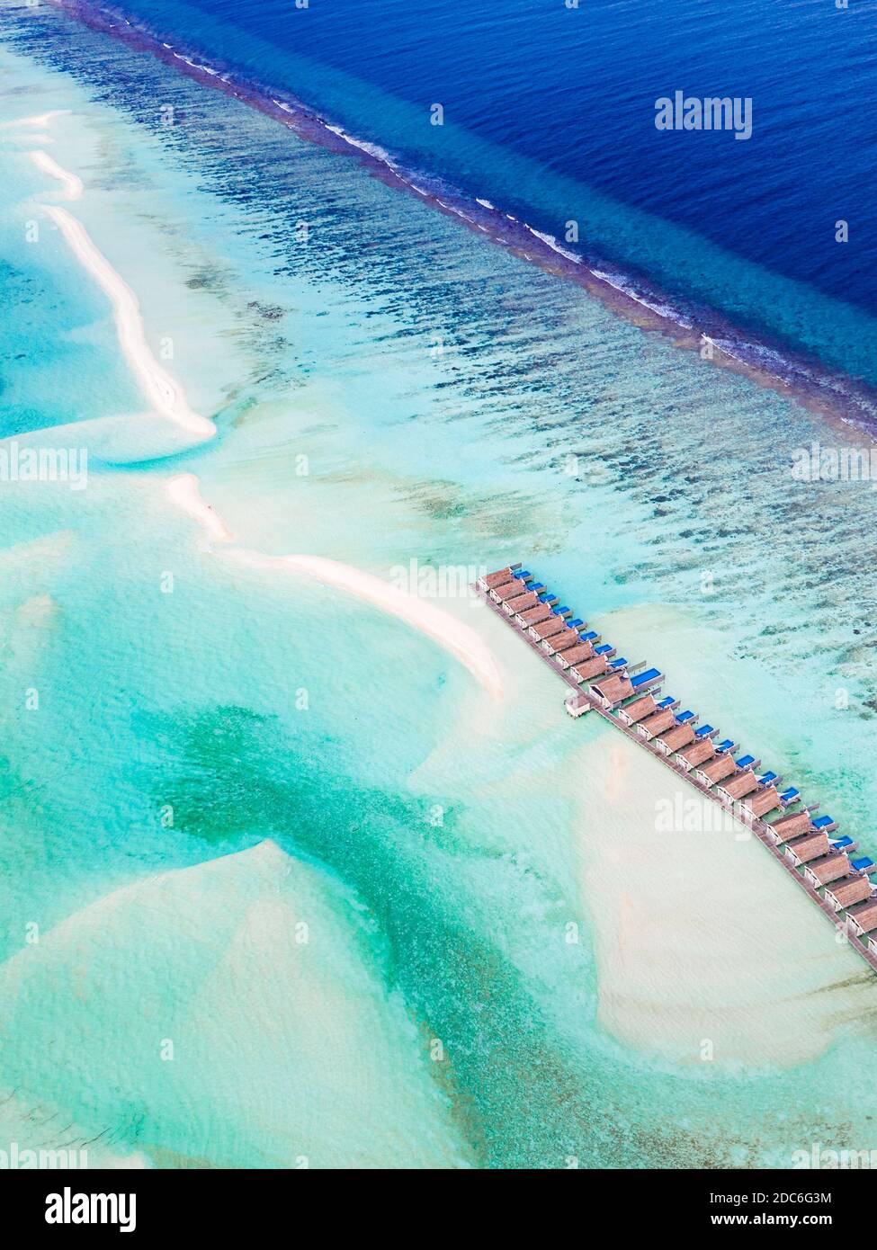 Landschaft mit Holzhotel am Meer, azurblauem Wasser, Sandstrand, grünen Bäumen, Boot. Luxus Resort Luftaufnahme, Küste, Küste des Riffs, erstaunliche Aussicht Stockfoto