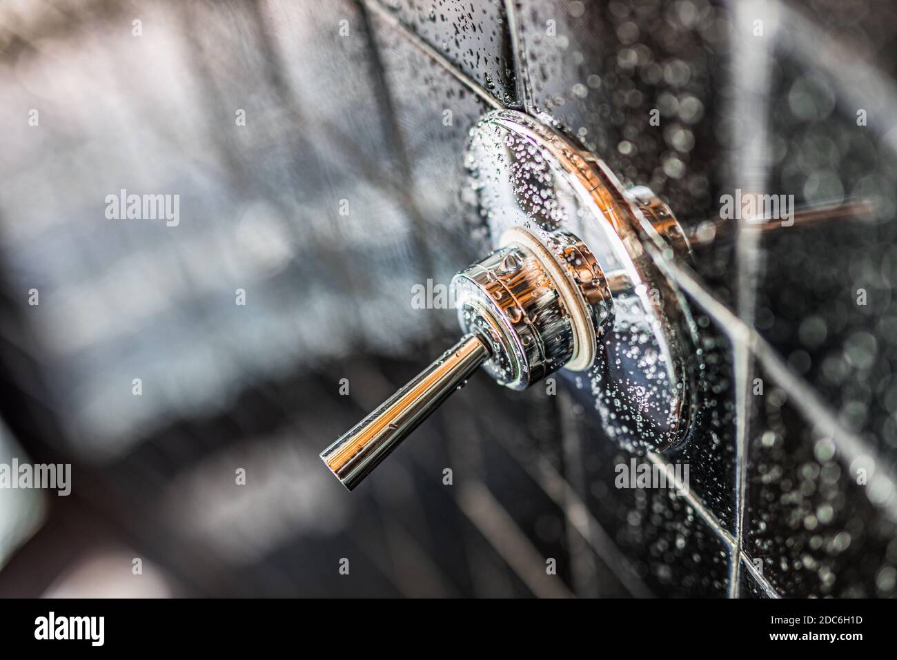Nahaufnahme der modernen schwarzen Dusche Badewanne mit blauen Vorhängen im Badezimmer in Modell Haus, Wohnung oder Haus, Fliesen, Wasserhahn, Tropfen Wasser Stockfoto