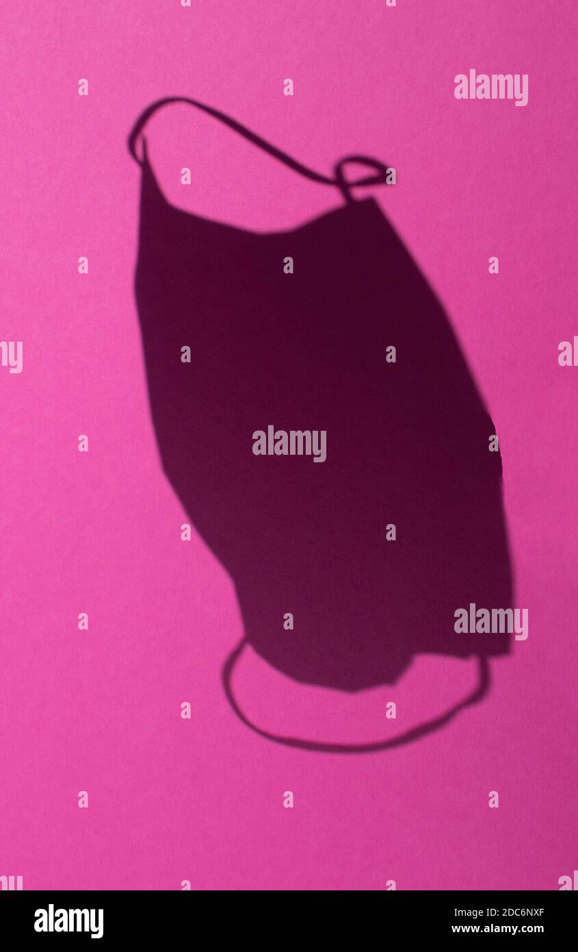 Selektive Fokussierung eines Sanitär Maske Schatten in der Luft Mit einem rosa Gesundheitskonzept Hintergrund Stockfoto