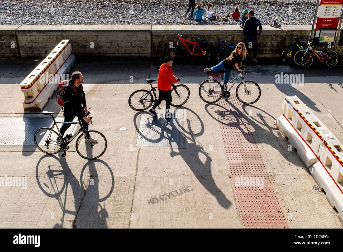 Menschen Radfahren entlang der Undercliff Walk in Rottingdean während der zweiten Covid 19 Lockdown, Rottingdean, East Sussex, Großbritannien. Stockfoto