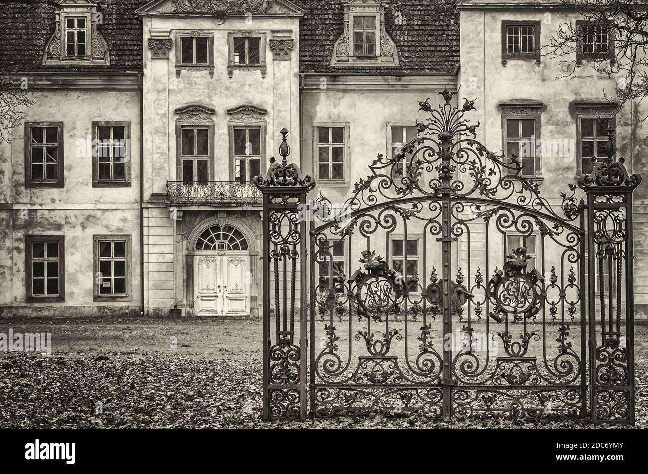 Ein altes Eisentor befindet sich vor einem baufälligen barocken Herrenhaus, Herrenhaus Ivenack, Mecklenburg-Vorpommern, Deutschland. Stockfoto