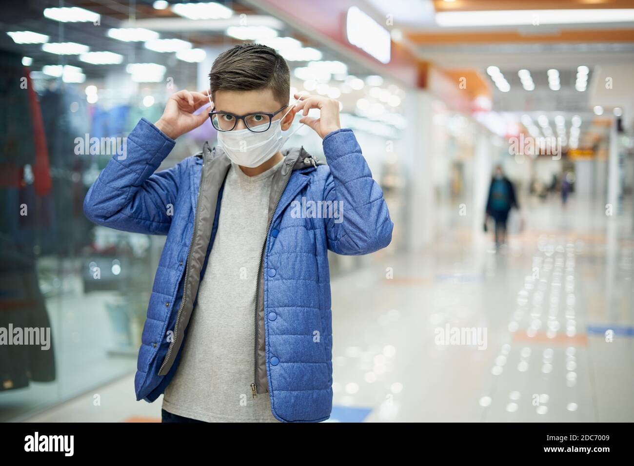 Kaukasischen weißen Teenager setzen auf Gesichtsmaske in Einkaufszentrum Stockfoto