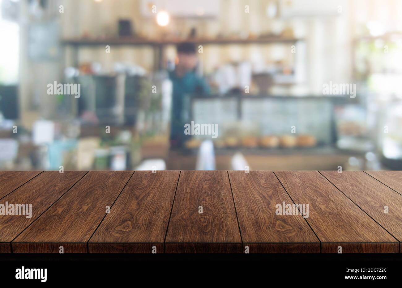Holztisch im verschwommenen Hintergrund eines modernen Restaurantzimmers oder eines Cafés mit leerem Kopierplatz auf dem Tisch für Produktdisplay-Modelle. Innen Stockfoto