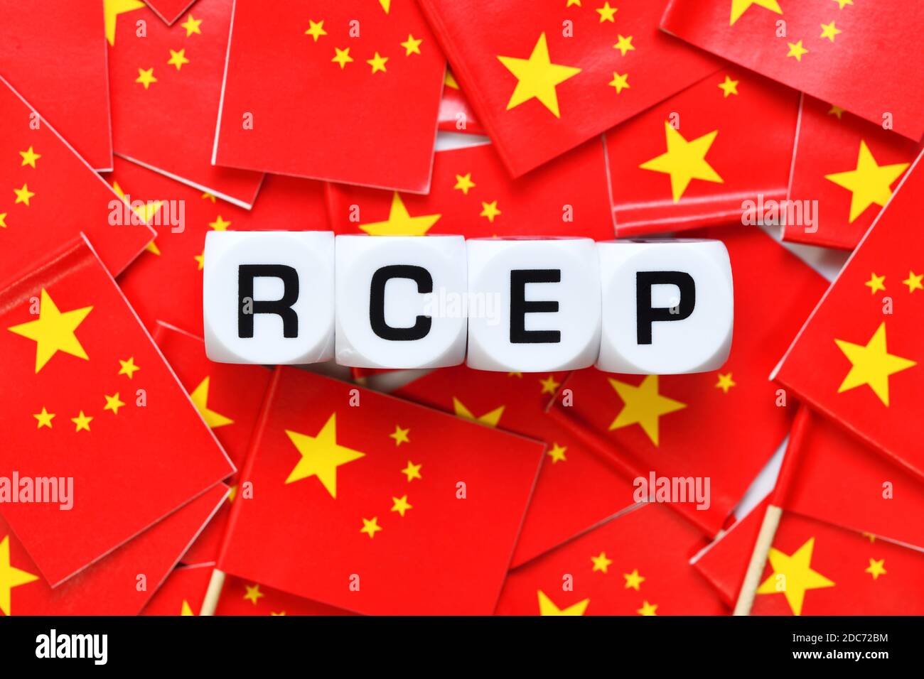 Buchstabenwürfel bilden RCEP auf Fahnen der Volksrepublik China, Asiatisches RCEP-Freihandelsabkommen Stockfoto