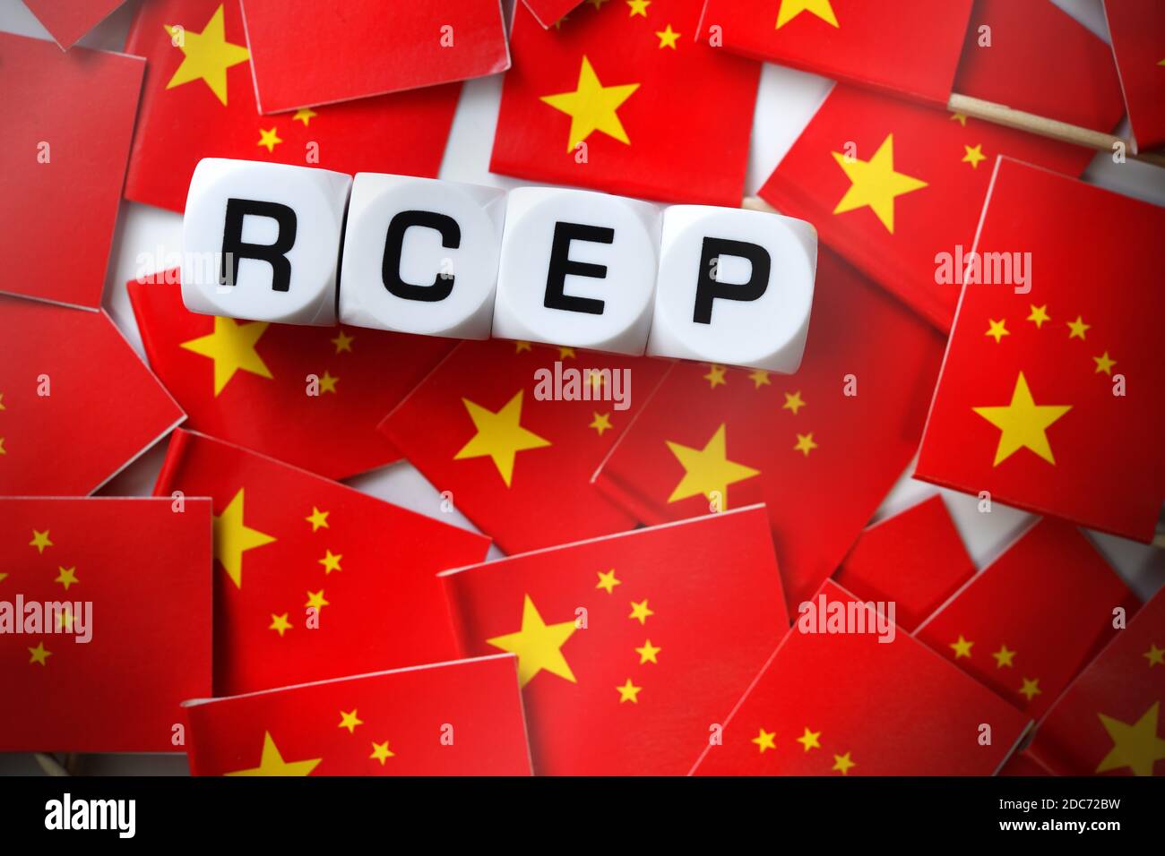 Buchstabenwürfel bilden RCEP auf Fahnen der Volksrepublik China, Asiatisches RCEP-Freihandelsabkommen Stockfoto