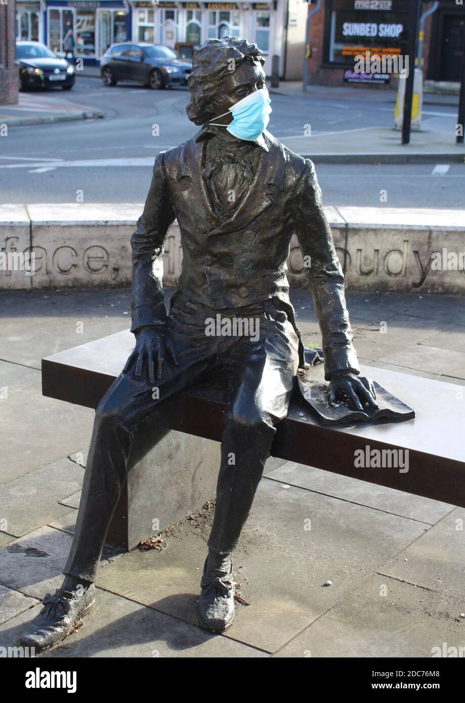 Ode an eine Gesichtsmaske von John Keats. Statue des Dichters John Keats in Chichester, West Sussex soziale Distanzierung mit dem Zusatz einer Gesichtsmaske. Stockfoto