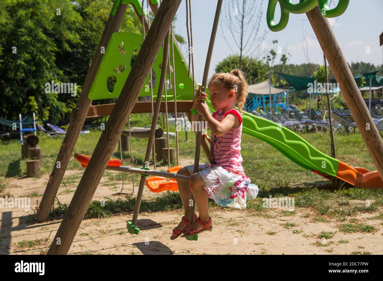 Kleine blonde Mädchen spielt im Park Stockfoto