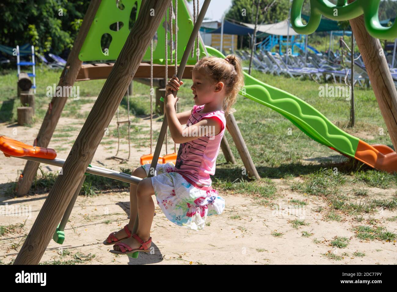 Kleine blonde Mädchen spielt im Park Stockfoto