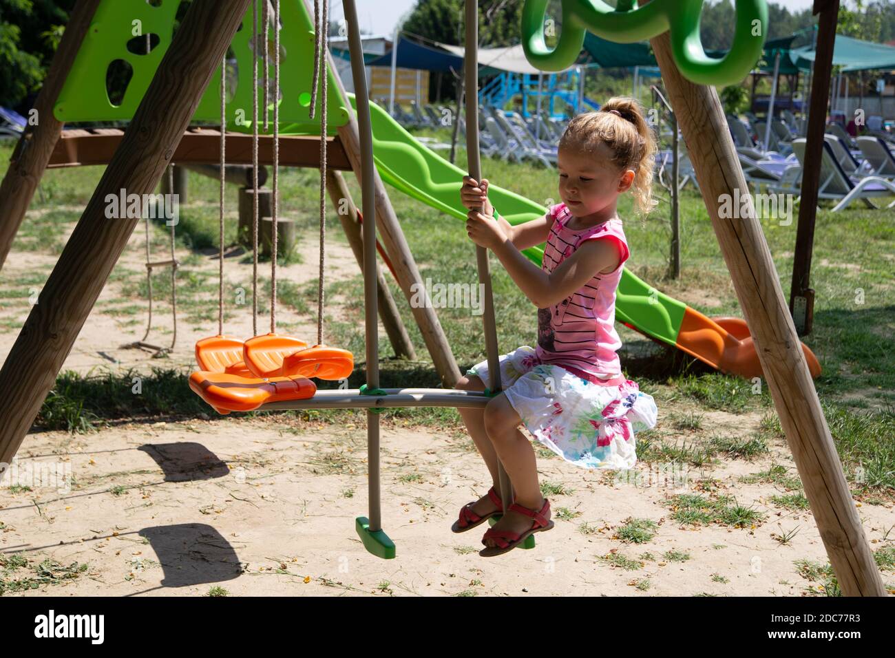 Kleine blonde Mädchen spielt im Park Stockfoto