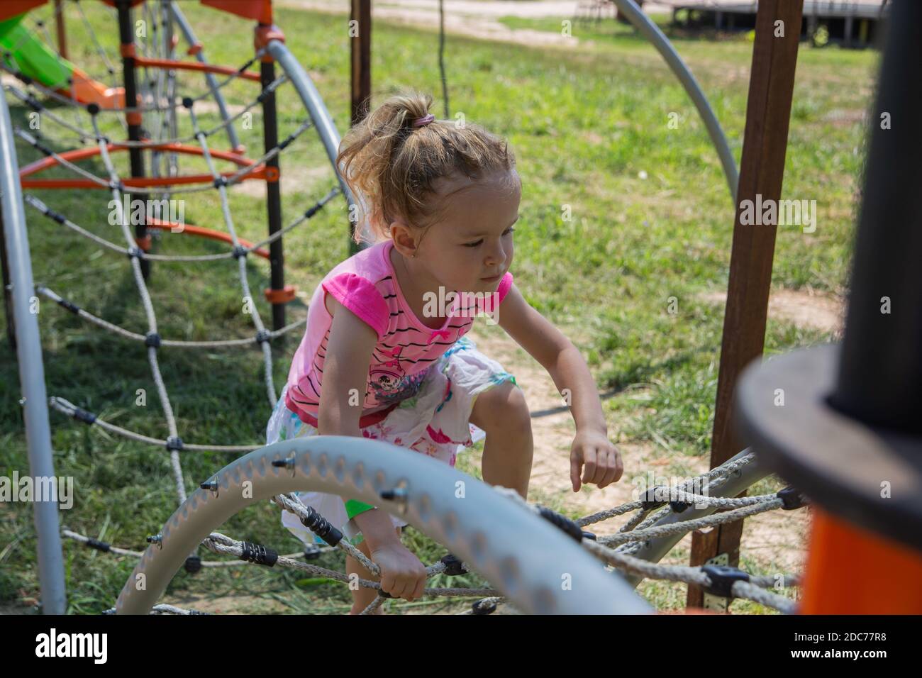 Kleine blonde Mädchen spielt im Park Stockfoto