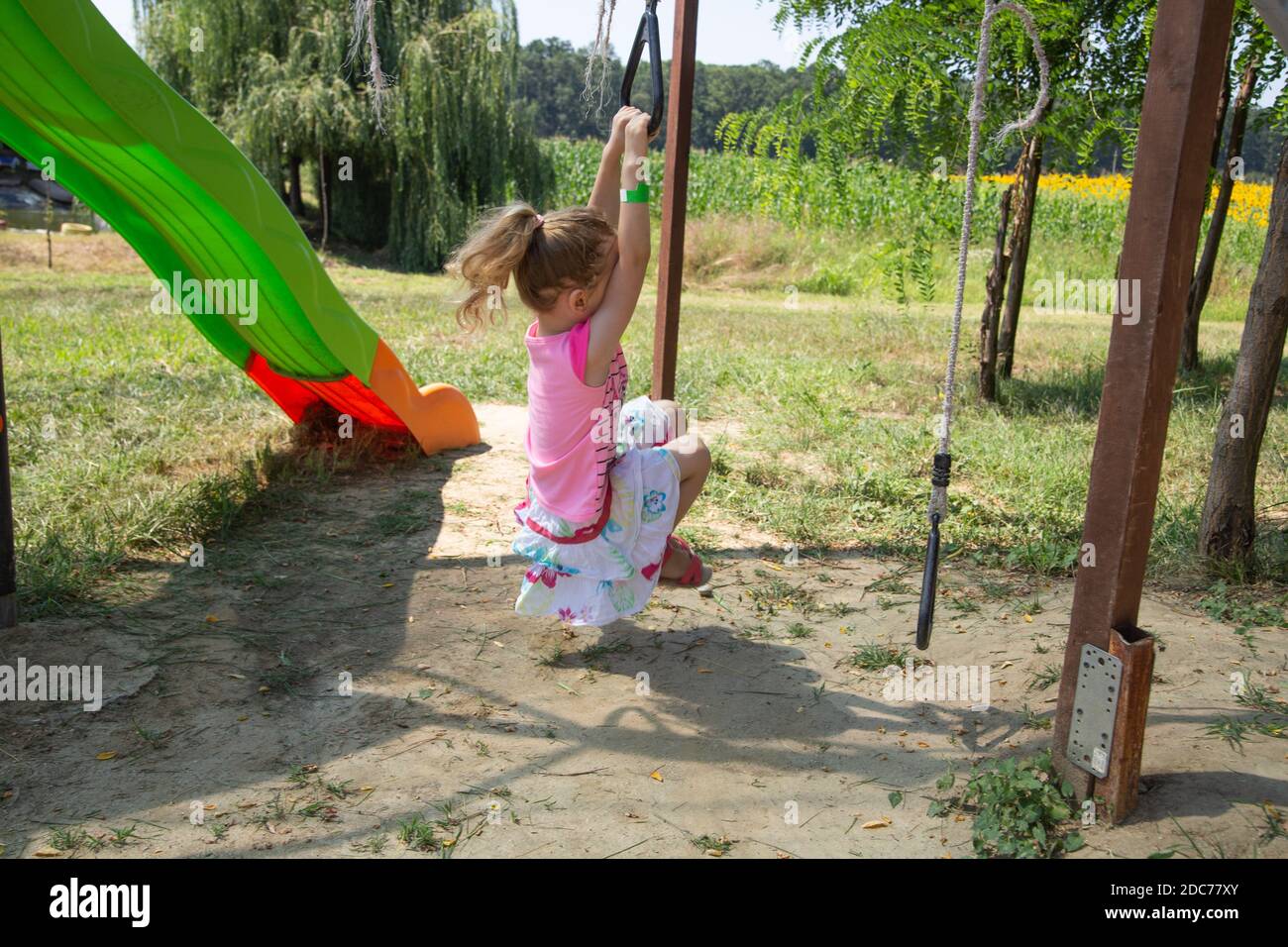 Kleine blonde Mädchen spielt im Park Stockfoto