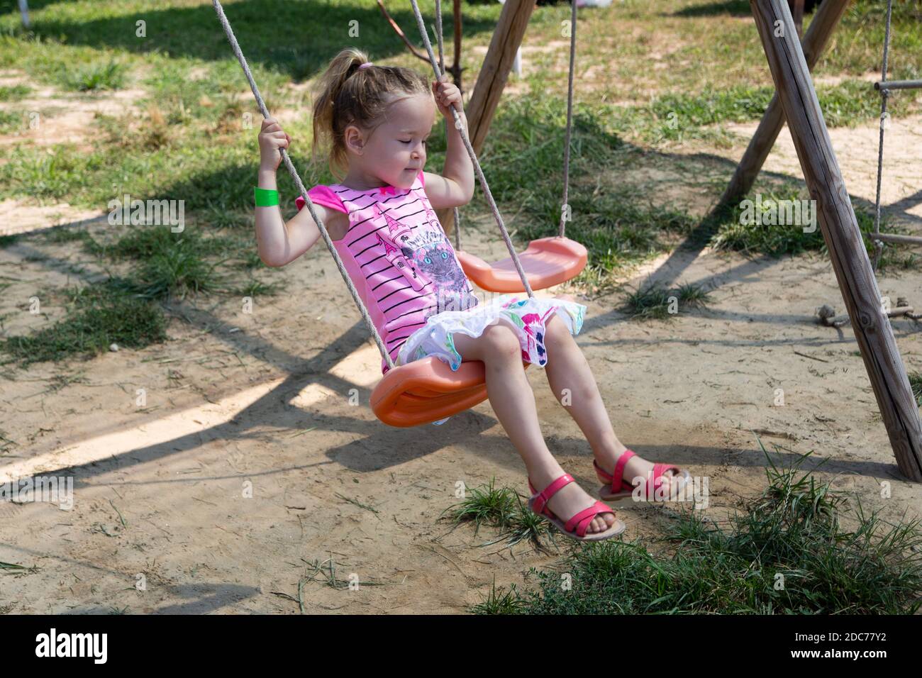 Kleine blonde Mädchen spielt im Park Stockfoto