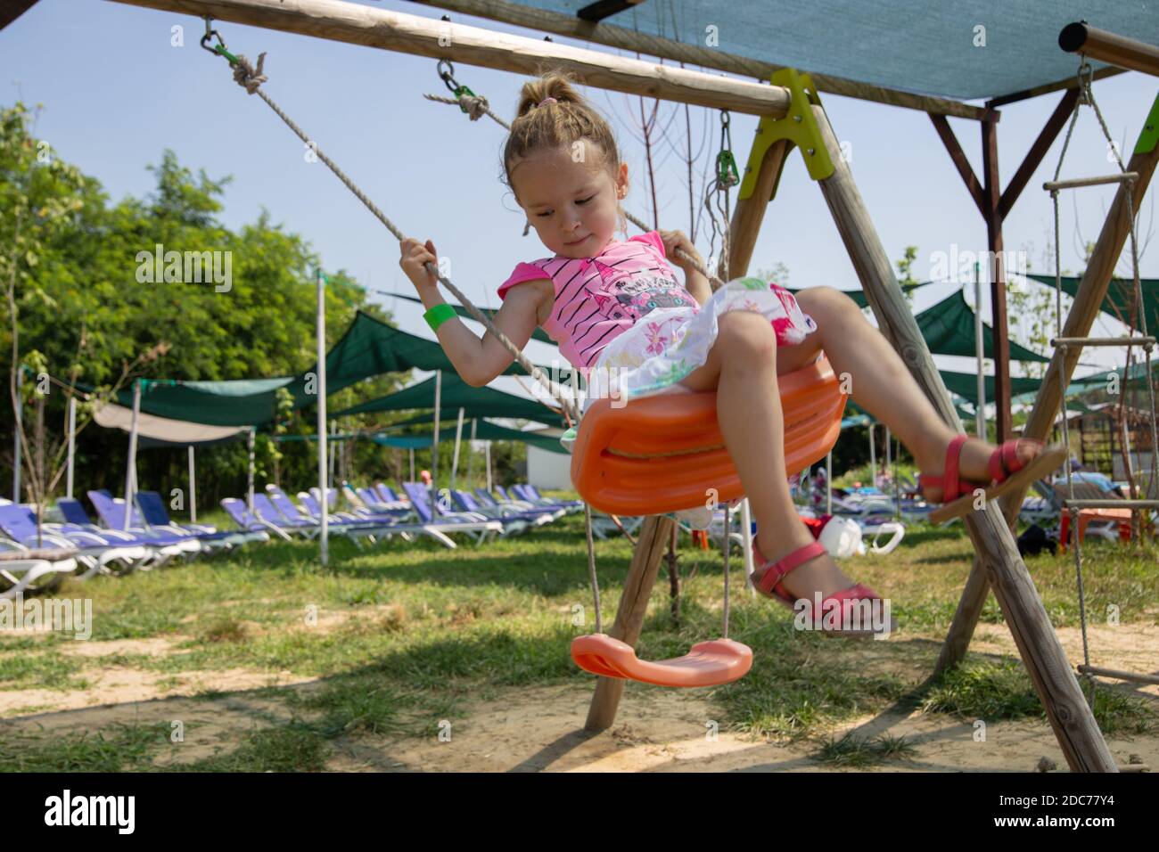 Kleine blonde Mädchen spielt im Park Stockfoto