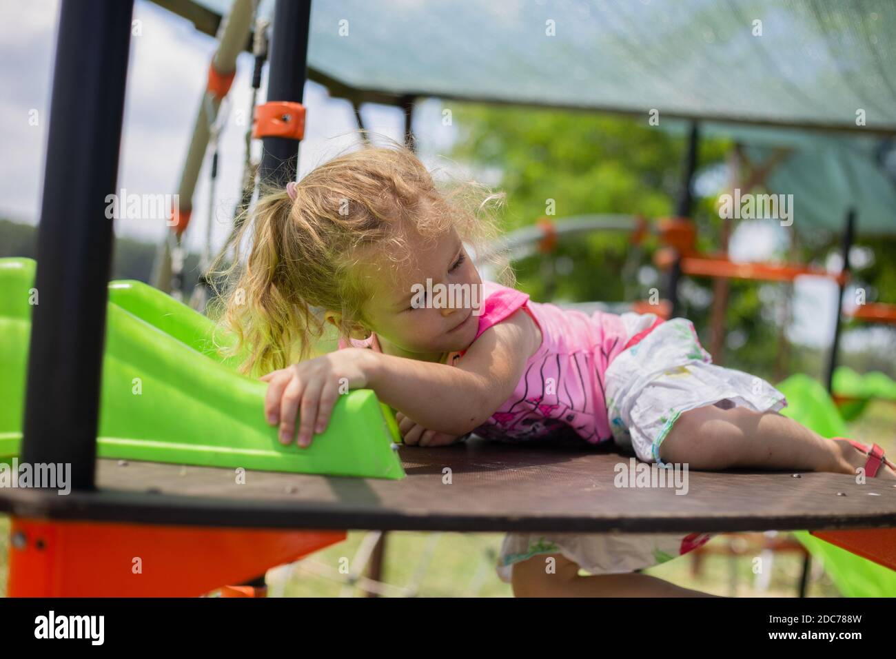 Kleine blonde Mädchen spielt im Park Stockfoto