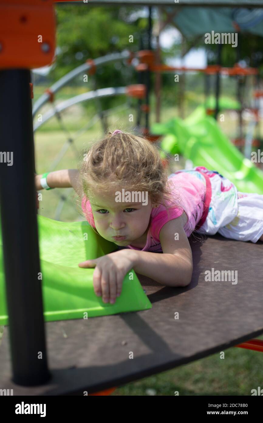 Kleine blonde Mädchen spielt im Park Stockfoto