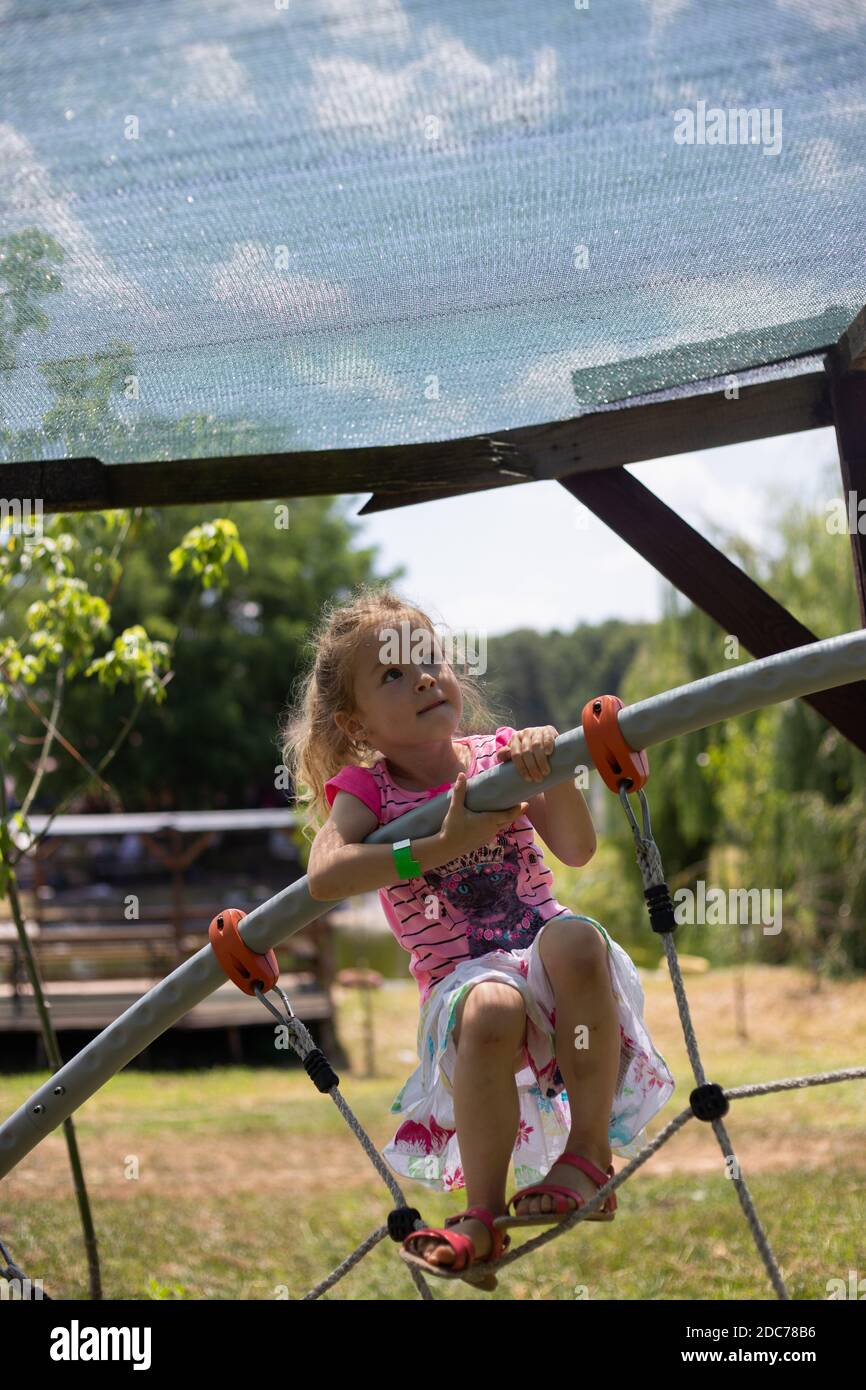 Kleine blonde Mädchen spielt im Park Stockfoto