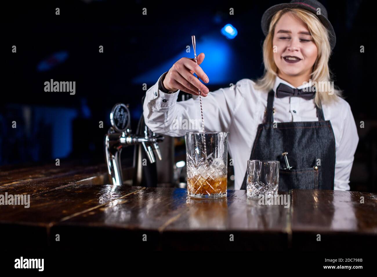 Junge Mädchen Barkeeper zeigt den Prozess der Herstellung eines Cocktails Stockfoto