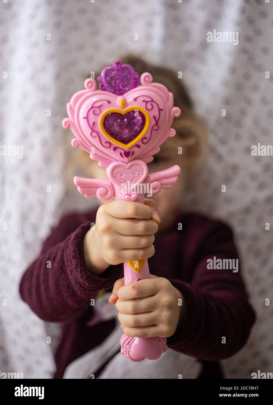 Eine Kinderhand, die einen Zauberstab hält Stockfoto