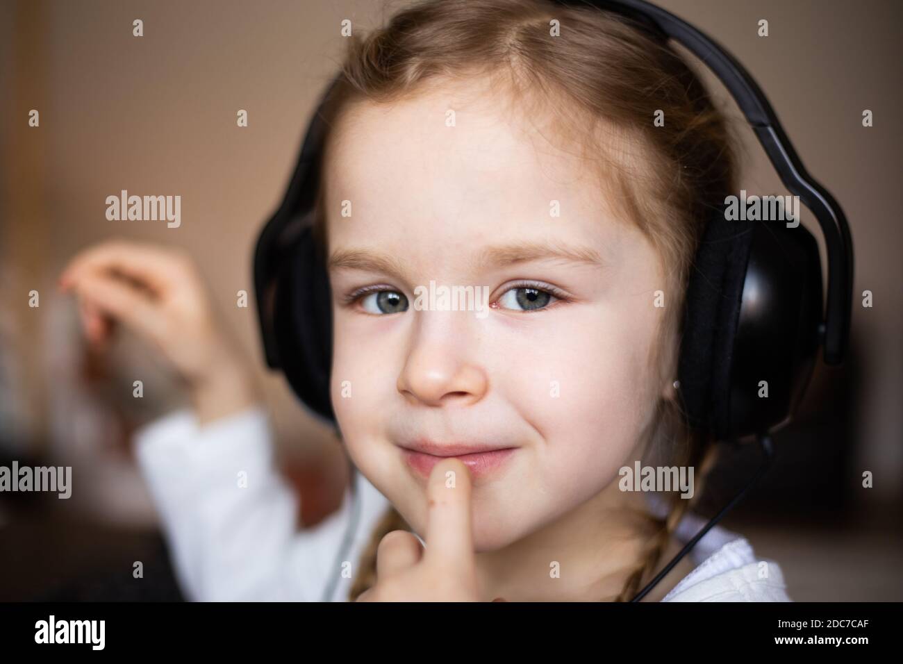 Kleines blondes Mädchen, das Musik hört Stockfoto