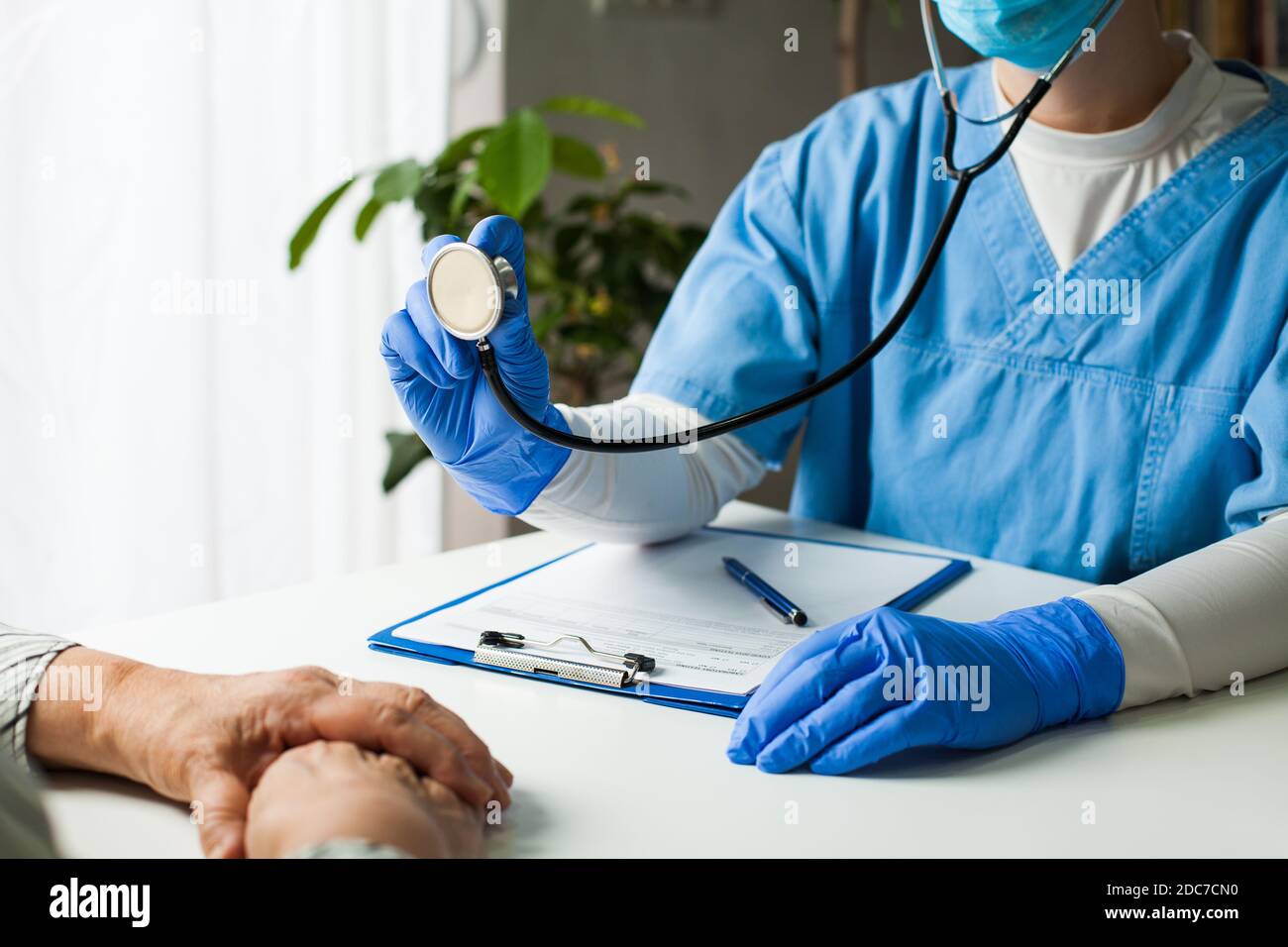 Hausarzt in der Arztpraxis, Arzt, der eine Blutdruckuntersuchung durchführt, dem Herz, den Lungen und den Darm des Patienten zuhört Stockfoto