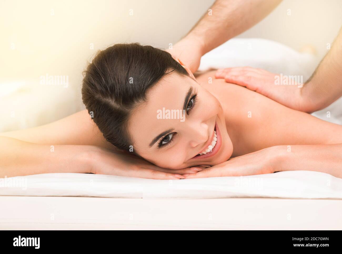 Lächelnde Mischrassenfrau während einer klassischen therapeutischen Rückenmassage In einem Wellness-Spa Stockfoto