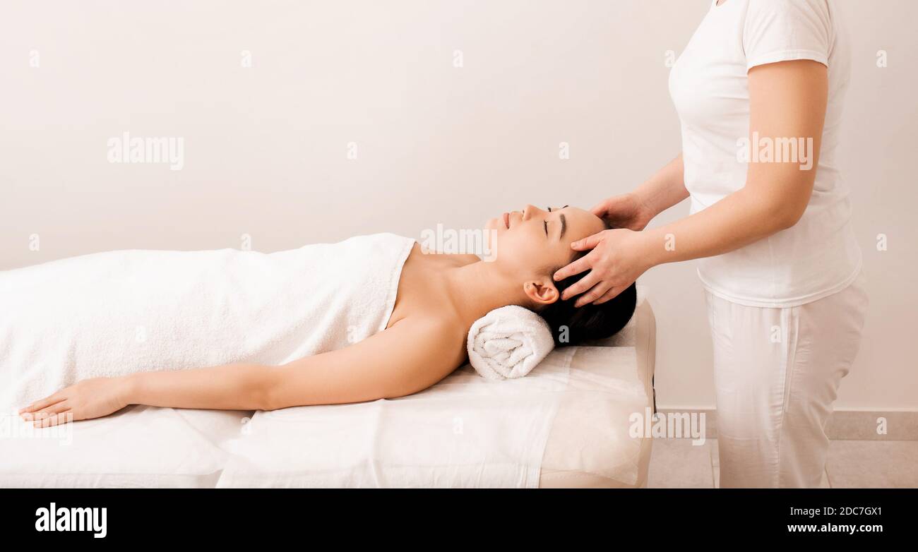 Thai-Massage. Asiatische Frau während Anti-Stress-Kopfmassage im Spa-Salon Stockfoto