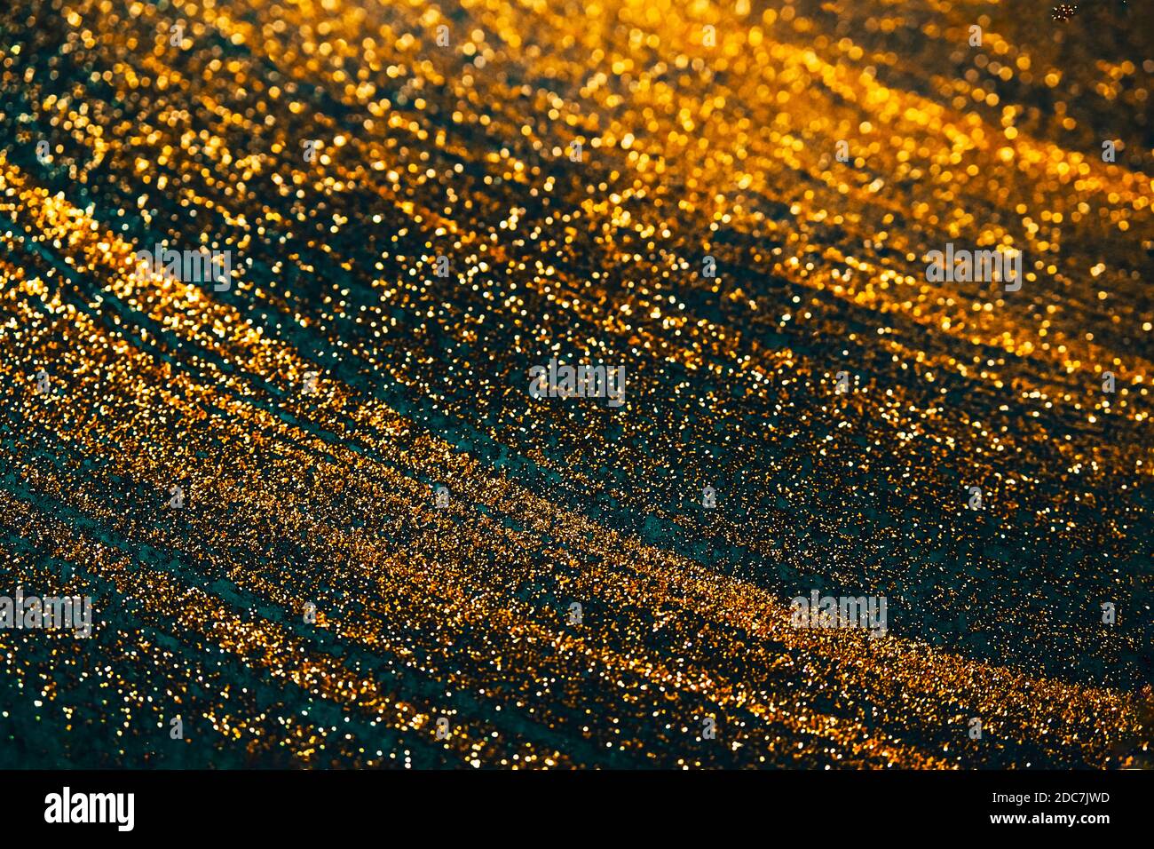 Gold Glitter auf grünen Bokeh abstrakt funkelnden defokussierten Hintergrund.Weihnachten, Silvester, Party, Feier Konzept. Farbe der dunklen Federn. Stockfoto