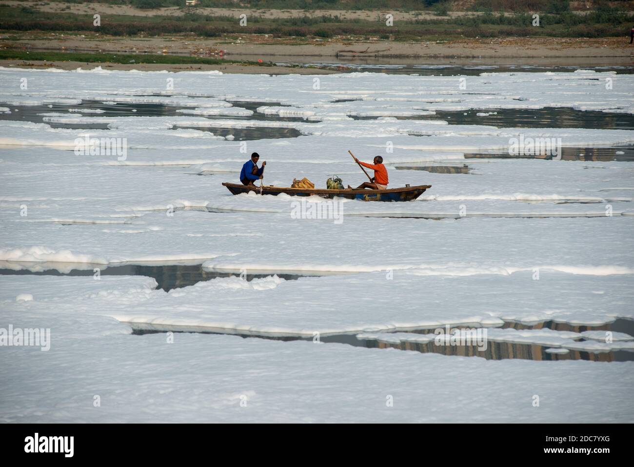 Neu Delhi, Indien. November 2020. Fischer rudern ihre Boote auf dem mit Schaum bedeckten Yamuna-Fluss.EINE dicke Schicht giftigen Schaums schwimmt auf dem Yamuna-Fluss in der Nähe von okhla Staustufe und Neu-Delhi, Yamuna ist einer der verschmutztesten Flüsse der Welt. Kredit: SOPA Images Limited/Alamy Live Nachrichten Stockfoto