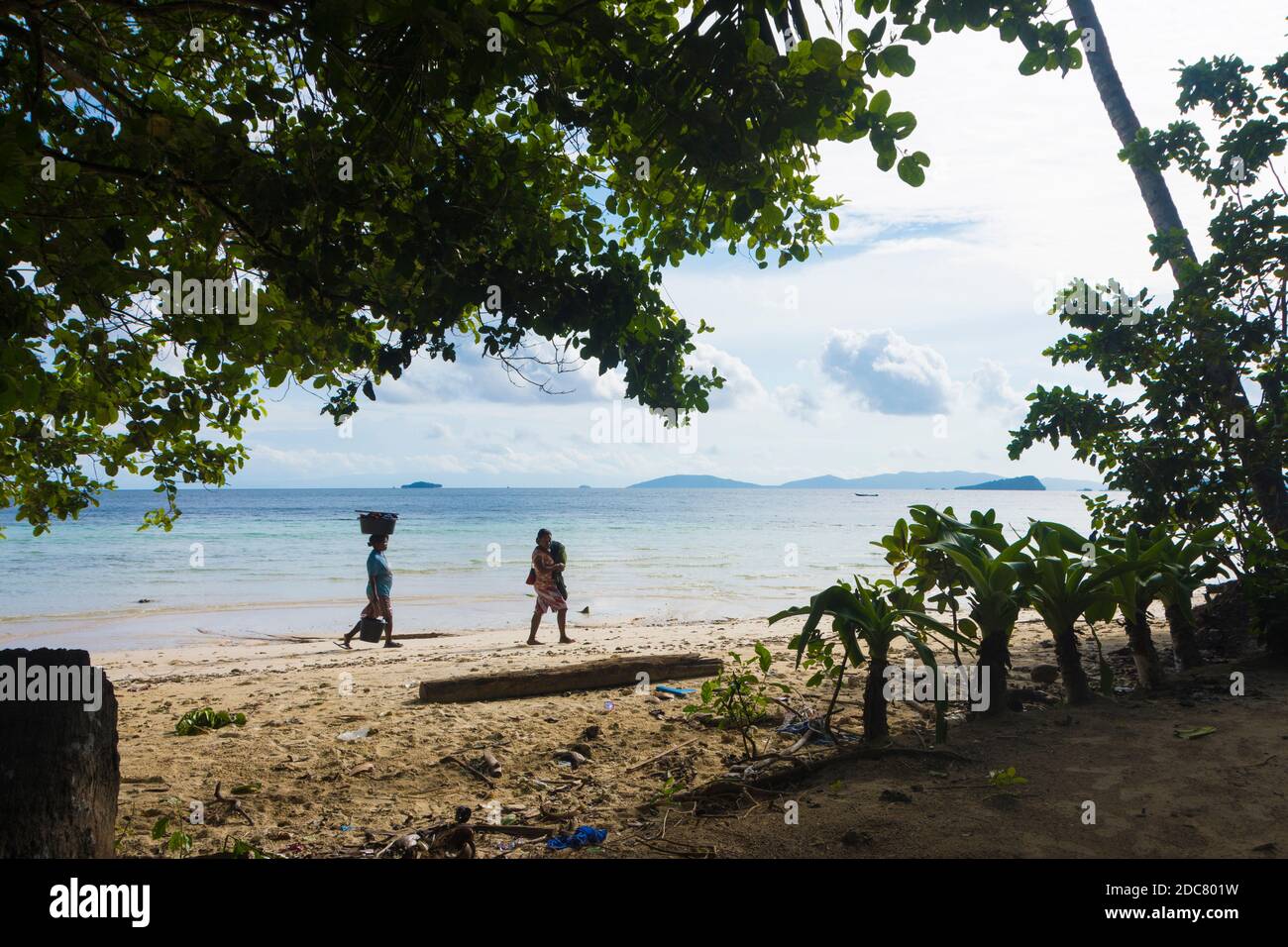 Zwei Frauen gehen am Strand einer der Raja Ampat Inseln, Indonesien. Stockfoto