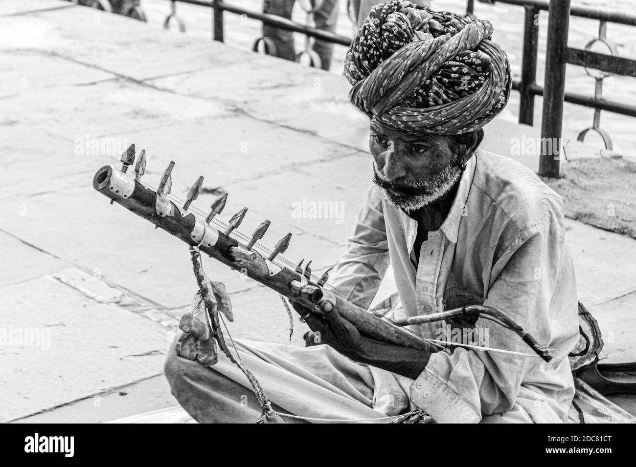 Der arme Musiker/Straßenkünstler am Straßenrand, der ein traditionelles Instrument spielt Von Rajasthan genannt ravanhatha Stockfoto