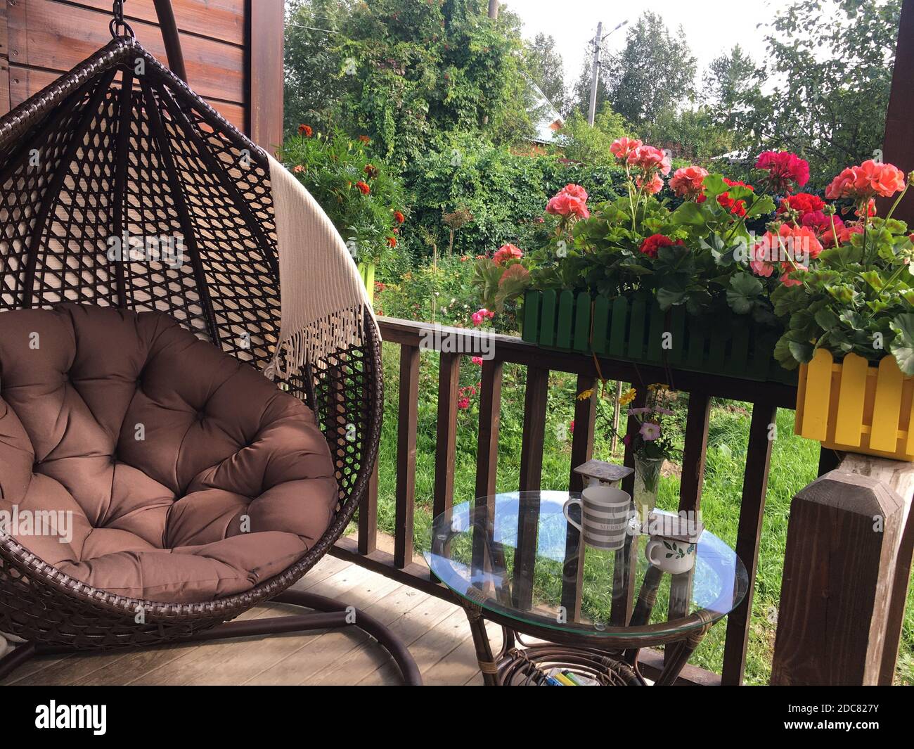 Schaukel und Blumen auf einem schönen gemütlichen Balkon Stockfotografie -  Alamy