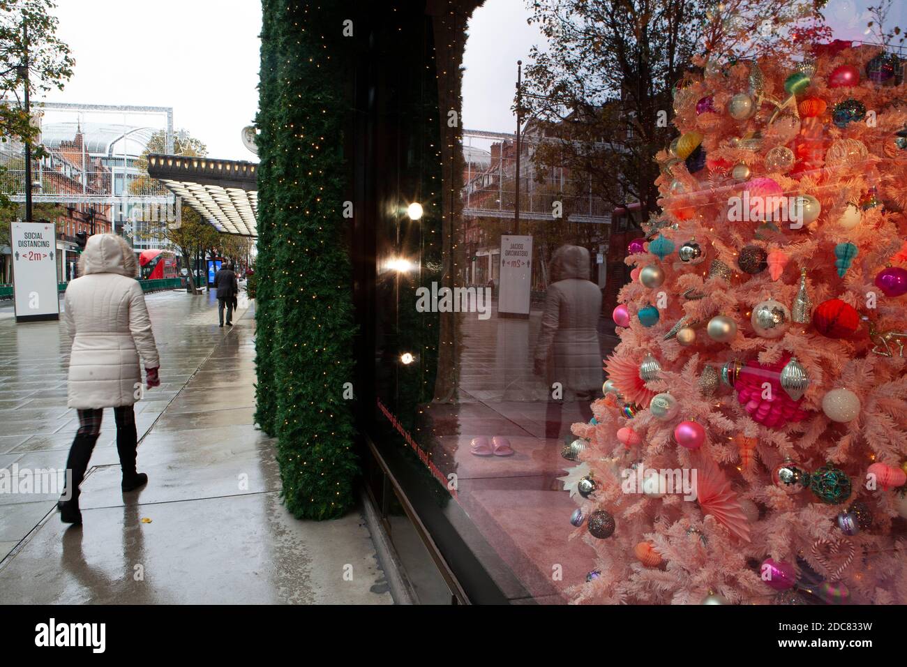 London, Großbritannien, 19. November 2020: Trotz Englands Lockdown und regnerischem Wetter gehen manche Leute zum Schaufensterbummeln oder benutzen Click and Collect im Londoner West End. Die Fenster des Kaufhauses Selfridges sind eine Attraktion für Passanten. Anna Watson/Alamy Live News Stockfoto